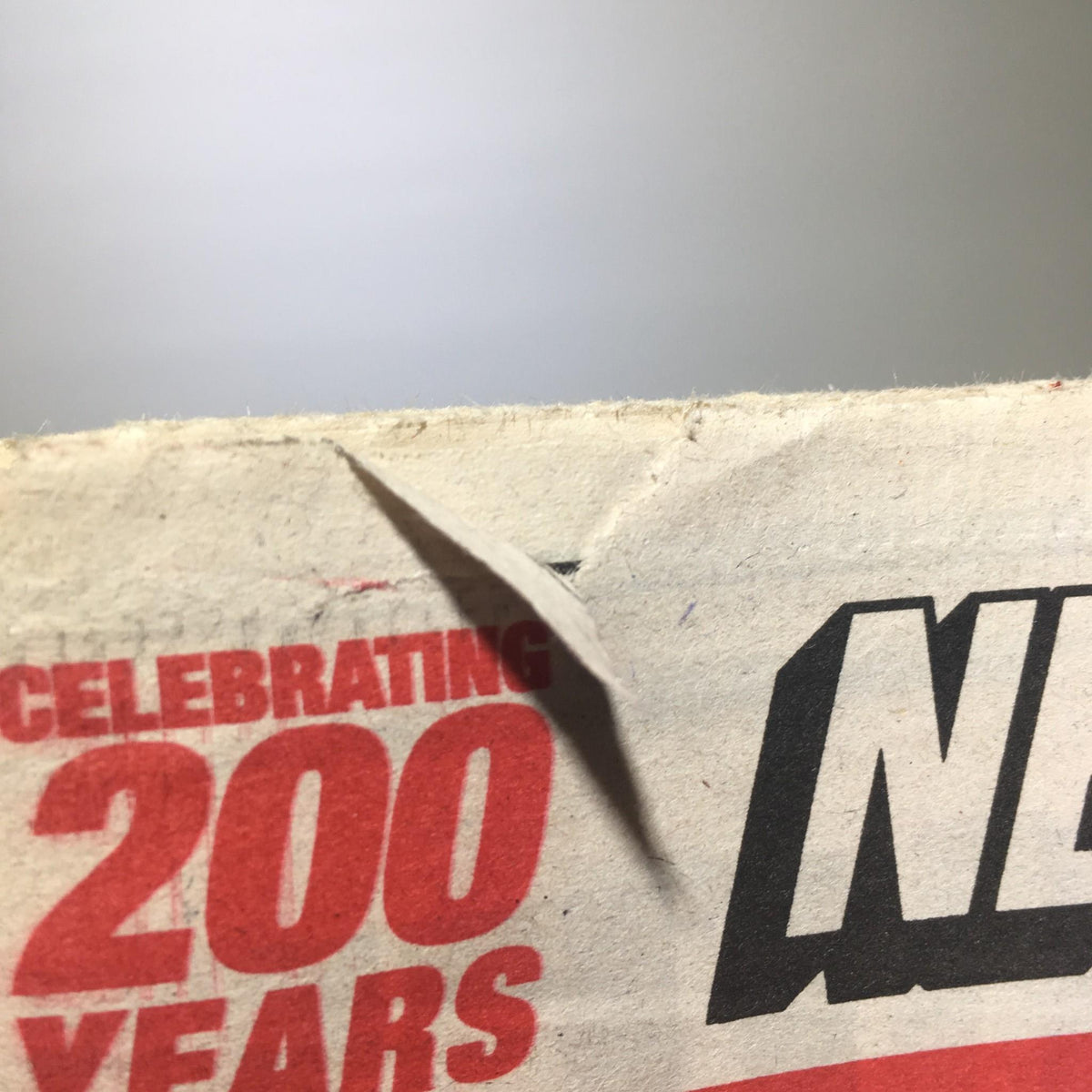 Detail of the New York Post featuring the 200 years celebration logo with a corner wear, showcasing the vintage aspect of the newspaper.
