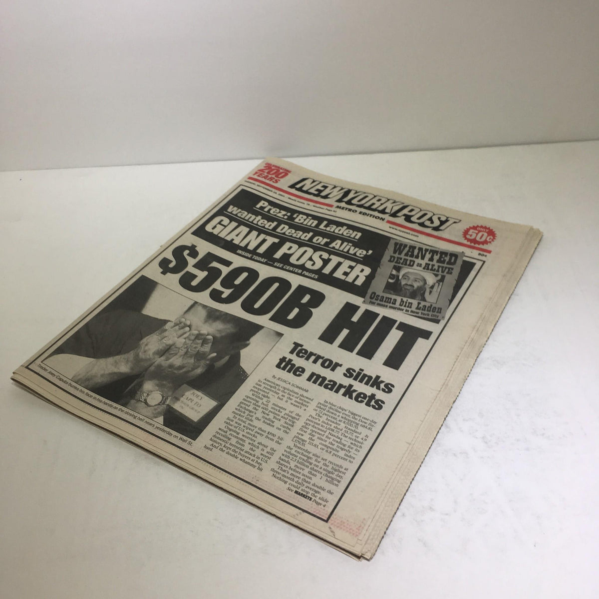 Side view of the New York Post issue titled 'New York Post: Sept 28 2001 $590 Hit Terror Sinks The Markets,' highlighting the dramatic headlines and imagery related to the financial impacts of terror.