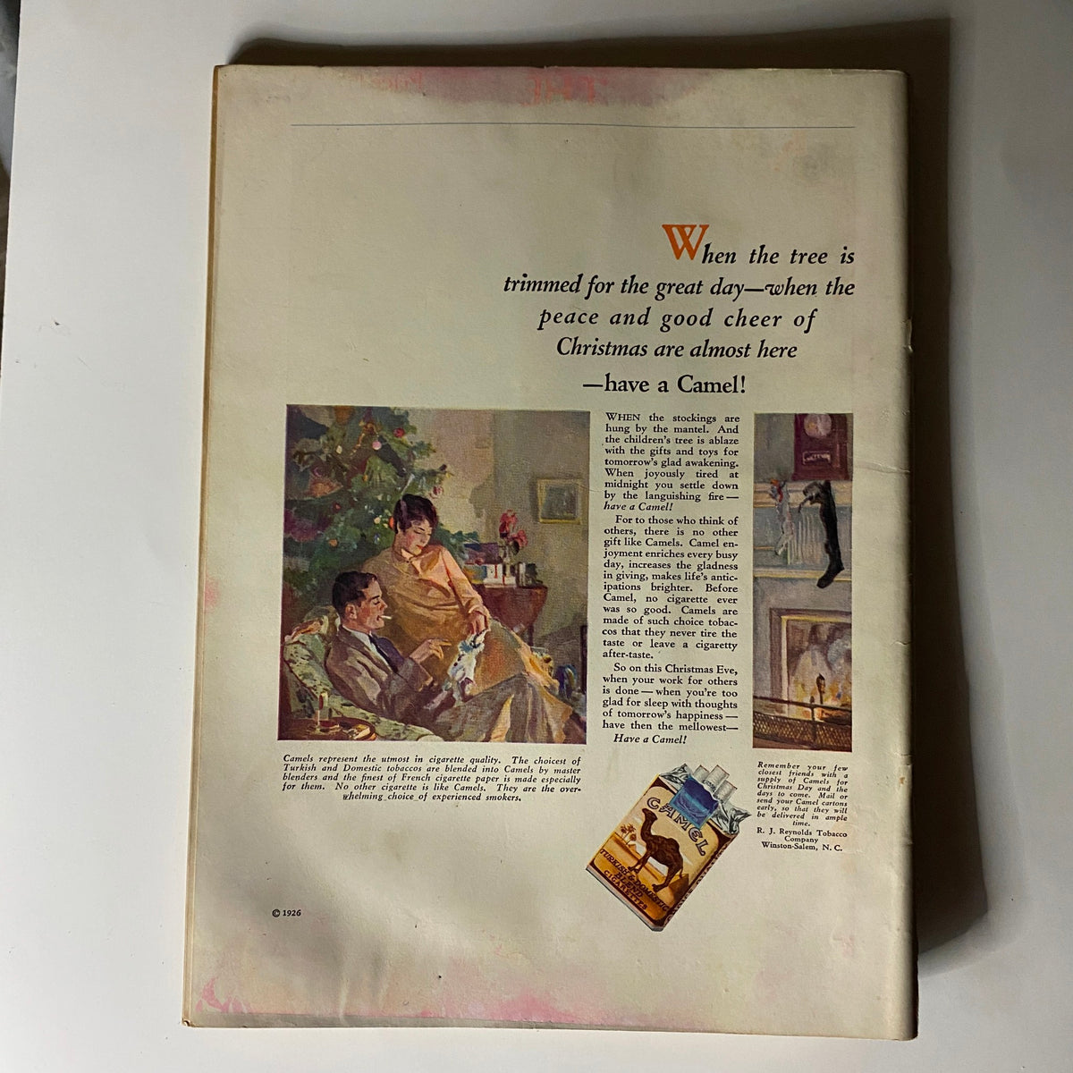 Back cover of The New Yorker Complete Magazine December 4, 1926 showcasing a festive illustration with a Christmas theme and an advertisement for Camel cigarettes.