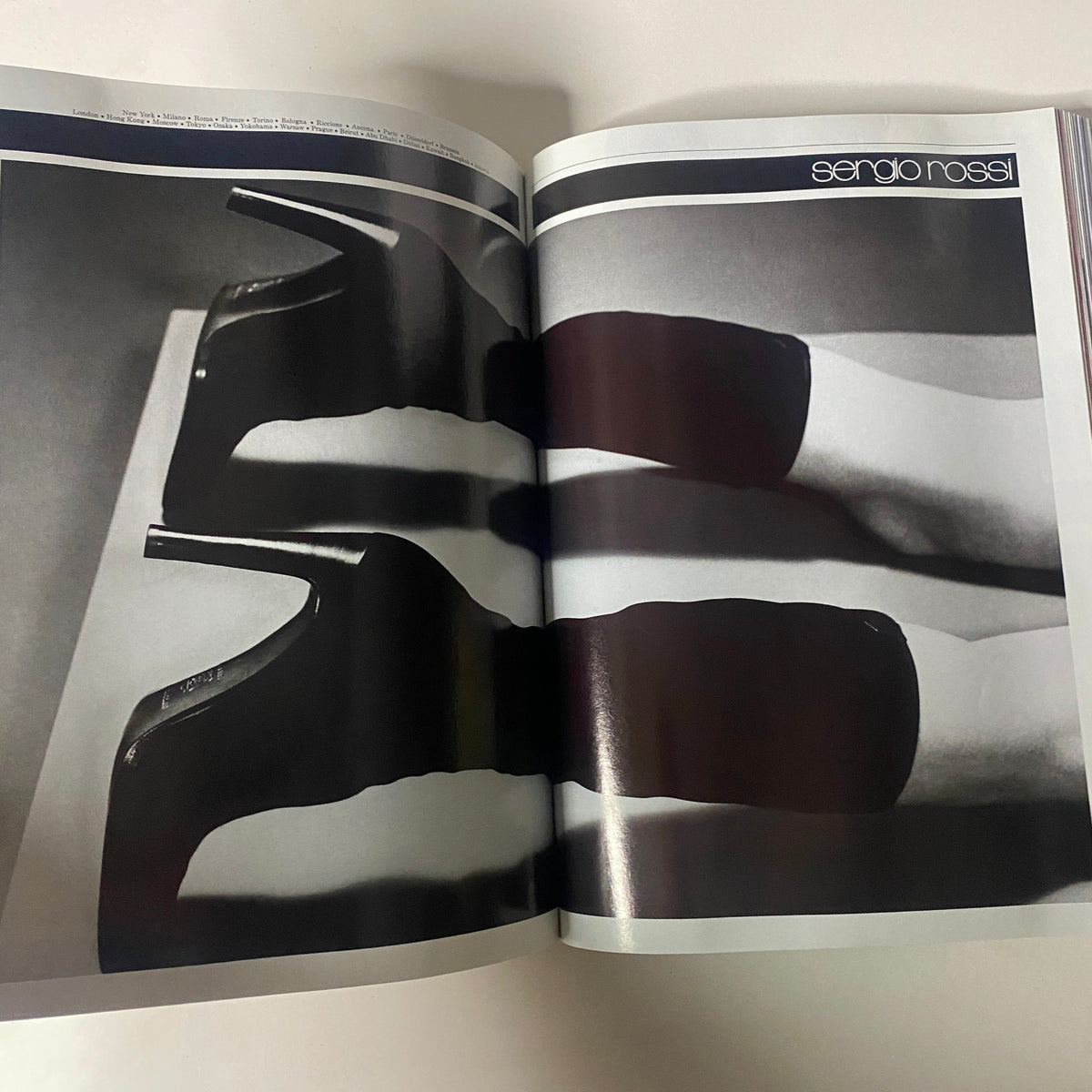 Sergio Rossi fashion advertisement from Vogue Magazine September 1997 featuring stylish black high-heeled boots. The visually striking monochrome image highlights modern fashion trends.