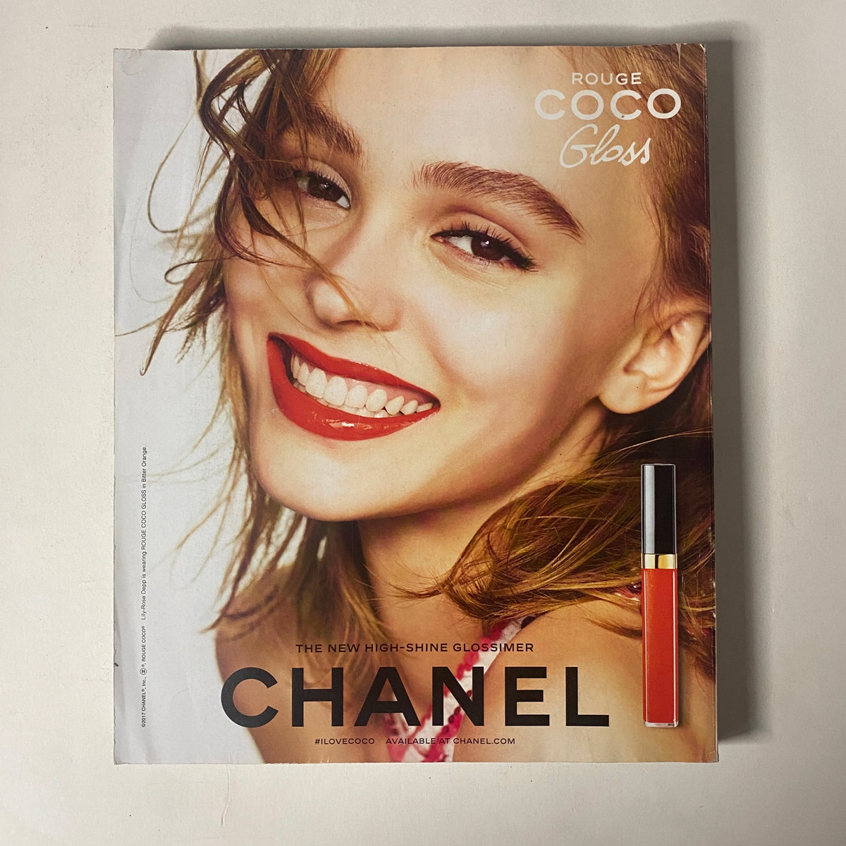 Vogue Magazine March 2017 presents a Chanel advertisement for Rouge Coco Gloss, showcasing a model with a radiant smile and glossy lips, highlighting the new high-shine lip product.