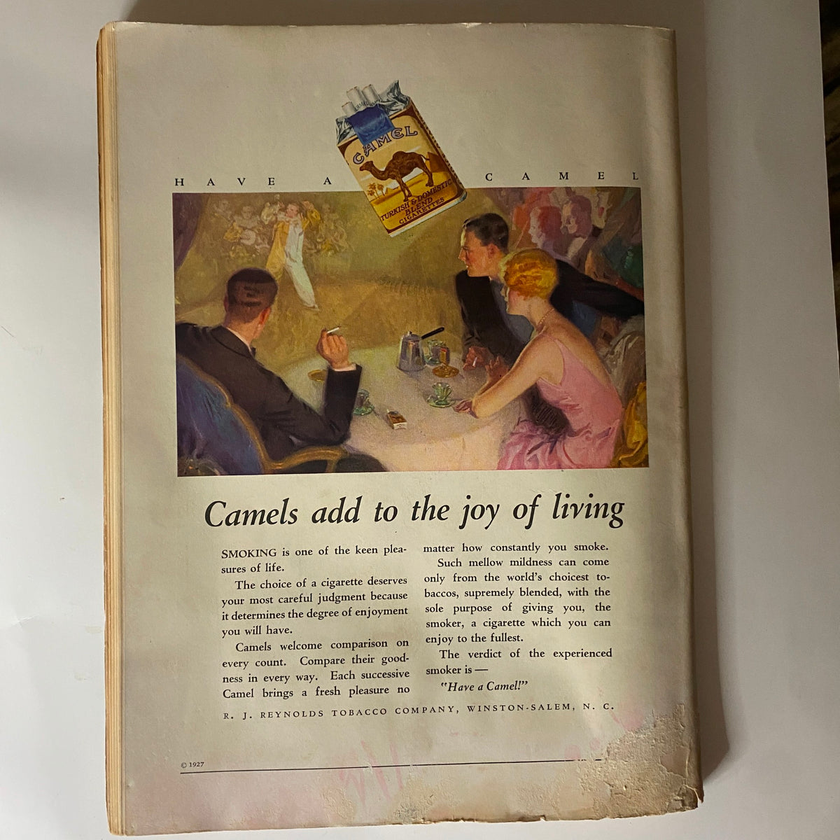Advertisement from The New Yorker Complete Magazine March 26, 1927 promoting Camel cigarettes, featuring an illustration of a social gathering and emphasizing the enjoyment of smoking.