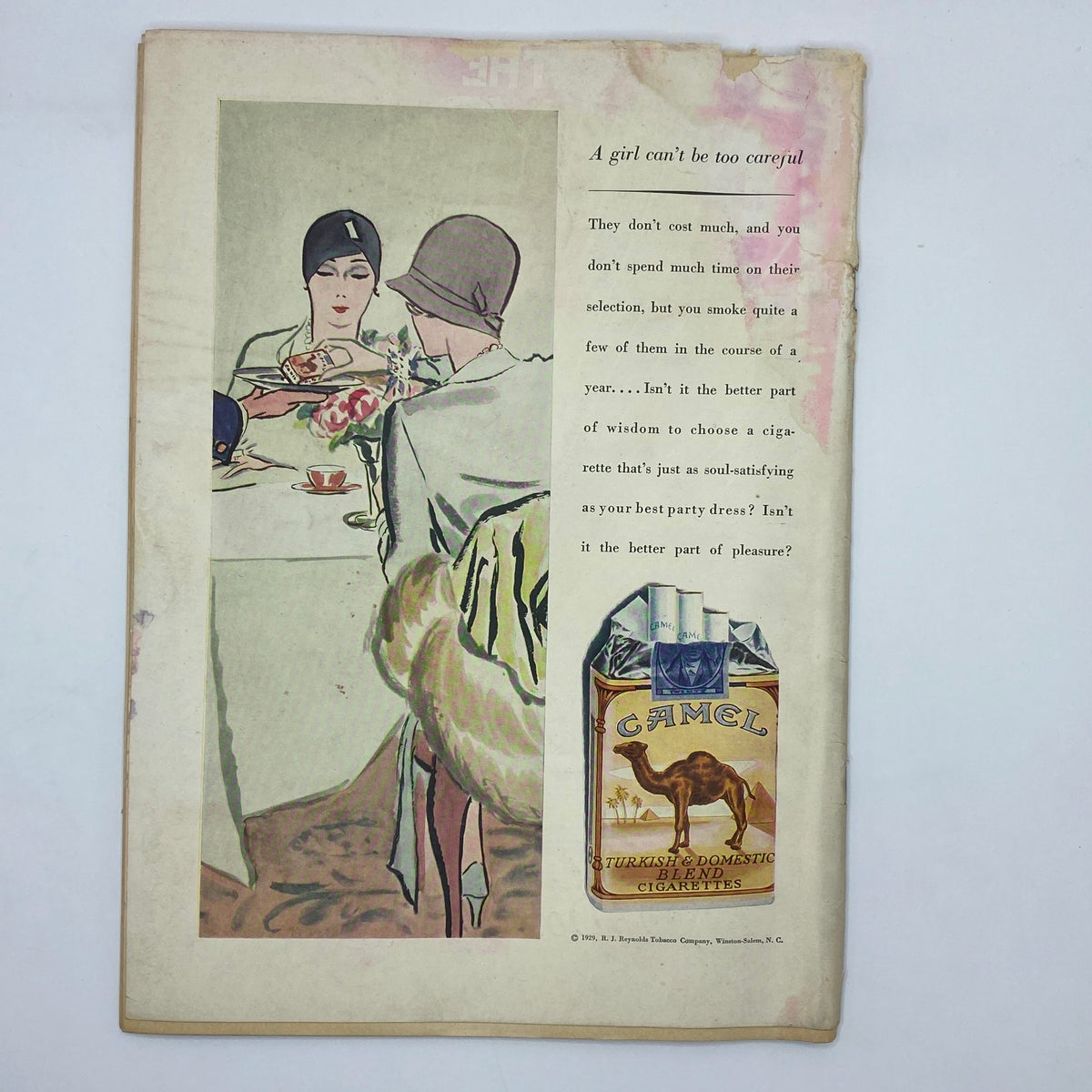 Vintage advertisement from The New Yorker Complete Magazine January 26, 1929 featuring a woman in a stylish flapper dress at a dining table, promoting Camel cigarettes with the tagline 'A girl can't be too careful'.