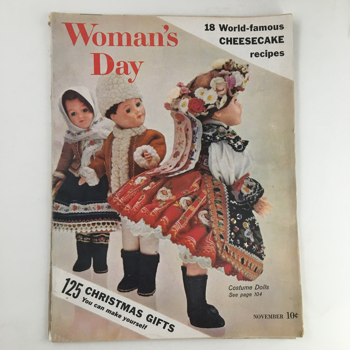Cover of Woman's Day Magazine November 1957 featuring Costume Dolls, showcasing traditional attire and holiday themes. Highlights include '125 Christmas Gifts' and '18 World-famous Cheesecake recipes.'