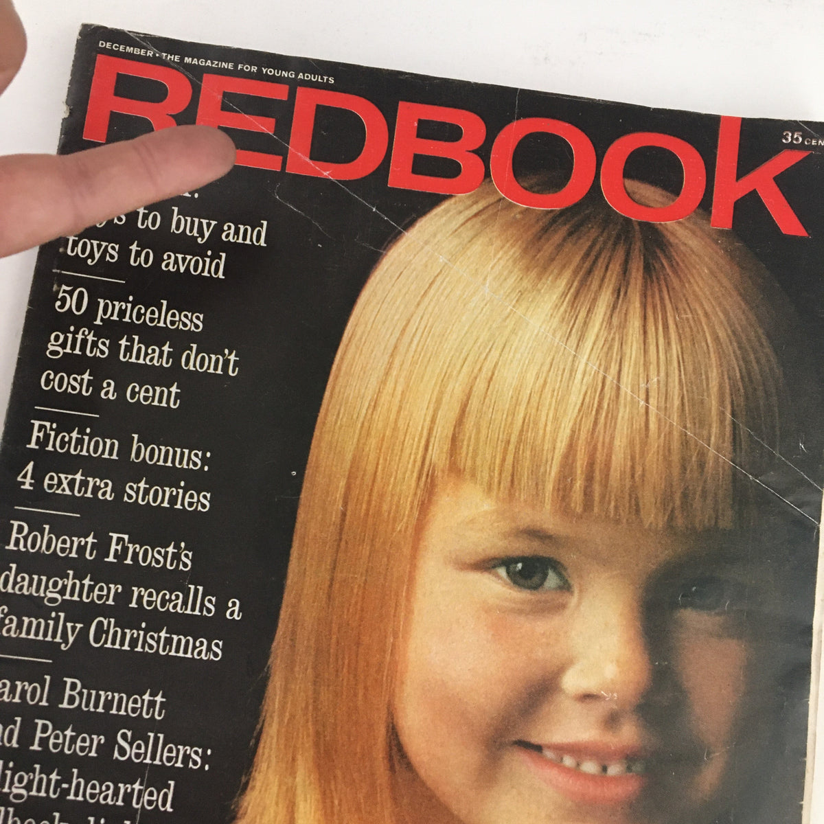 Close-up of the Redbook Magazine December 1963 cover featuring the title. The cover highlights an anecdote by Robert Frost's daughter about family Christmas celebrations, with a young girl smiling.