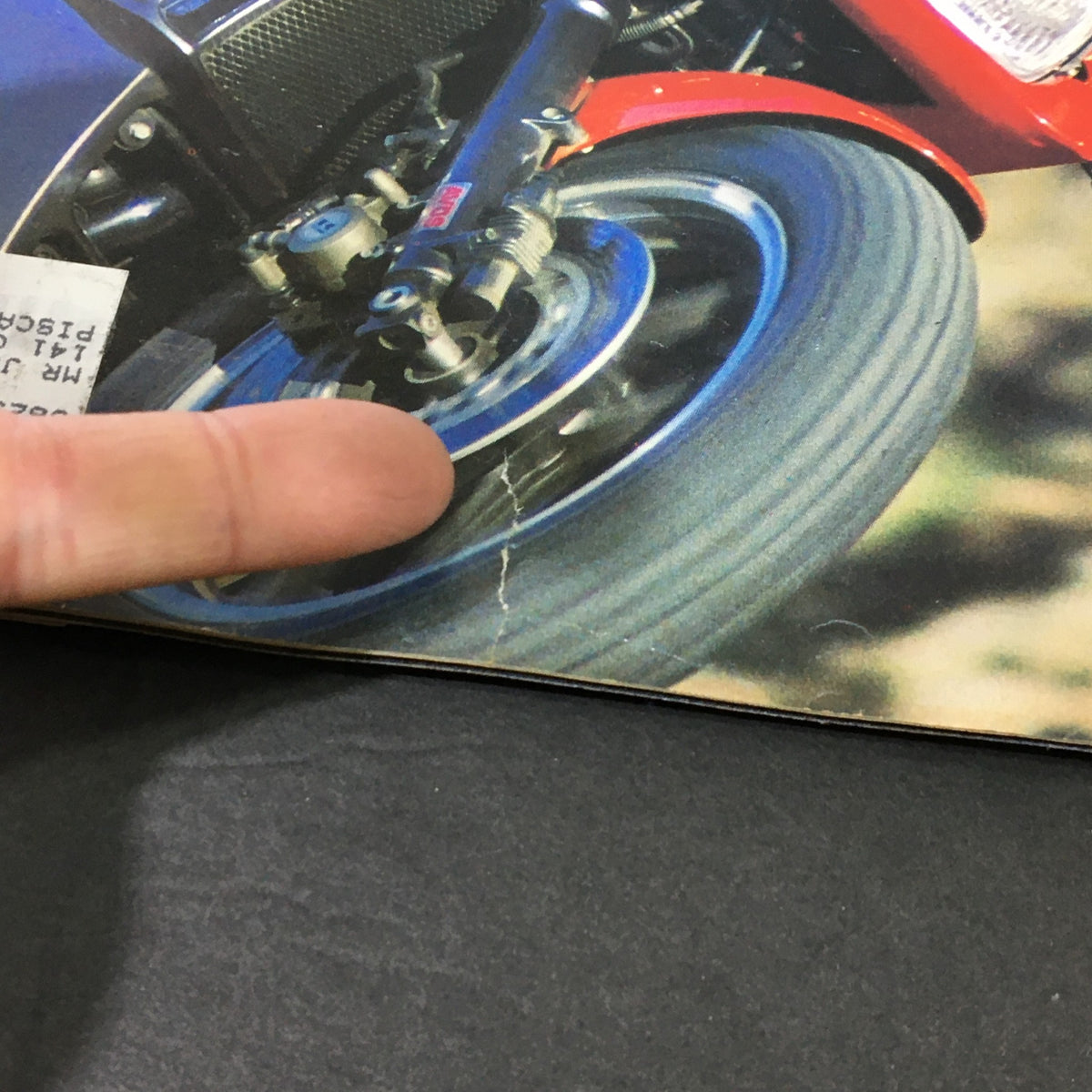 Detailed view of the Kawasaki 900 Ninja front wheel from Vintage Cycle Magazine March 1984, highlighting minor wear and tear visible on the magazine.