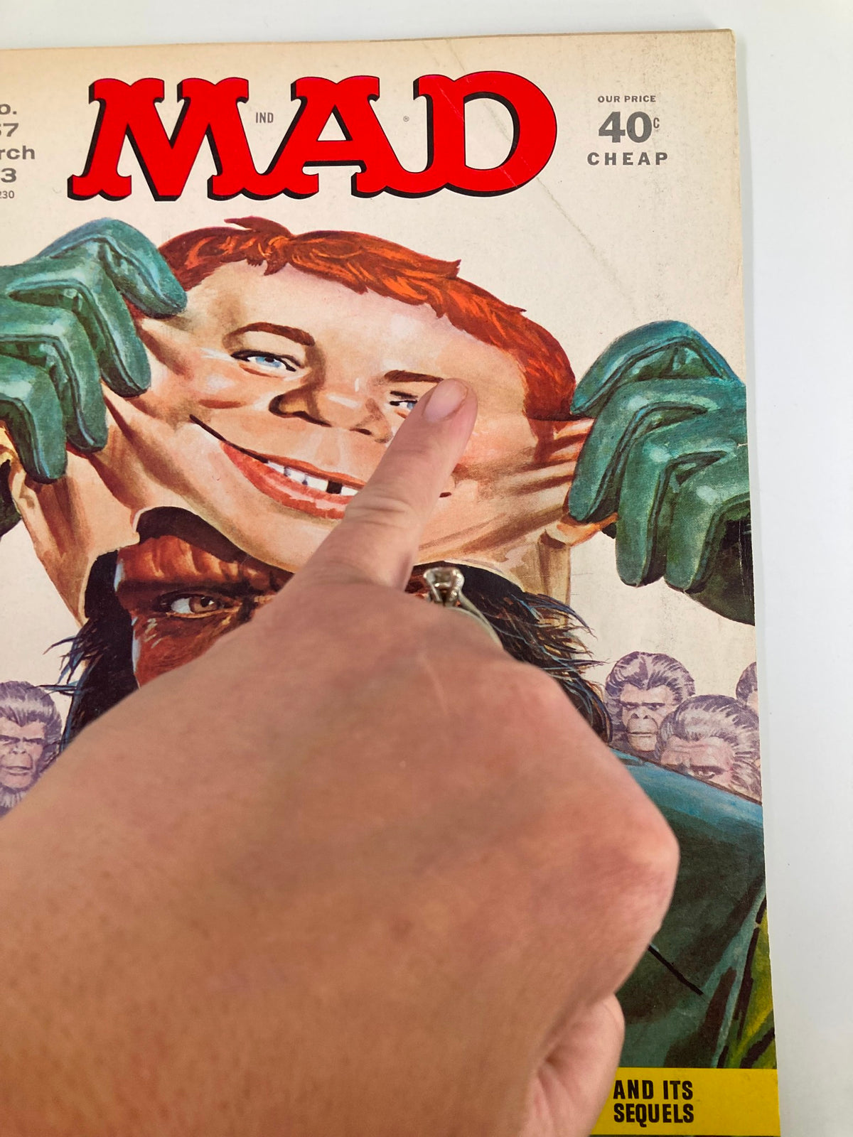 Close-up of the Mad Magazine March 1973 No. 157 cover, highlighting the character's exaggerated grin and playful gesture of pulling a mask, central to the 'Planet of The Apes' theme.
