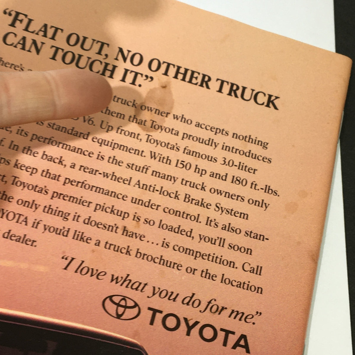 Back cover of a vintage magazine showing a Toyota truck advertisement with the quote, 'Flat out, no other truck can touch it.'