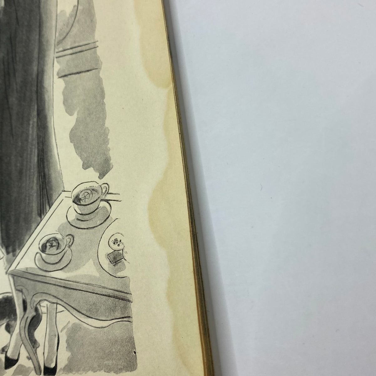 Close-up detail of a fashion ad in The New Yorker April 16, 1932, showing a table with tea sets and stylish women's clothing.