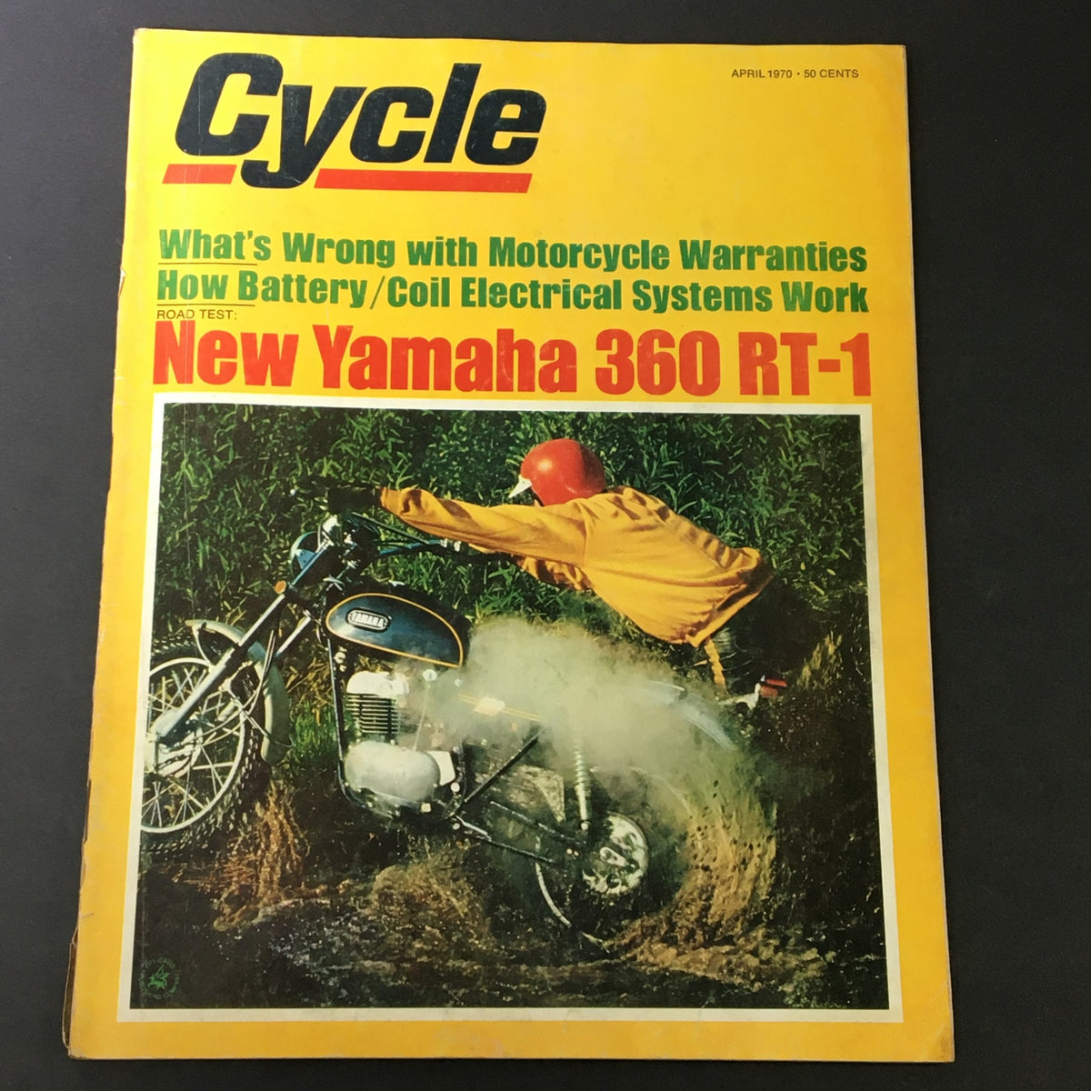Cover of VTG Cycle Magazine April 1970 showcasing the New Yamaha 360 RT-1, featuring vibrant colors and an action shot of a motorcycle in muddy terrain. Includes articles on motorcycle warranties and electrical systems.