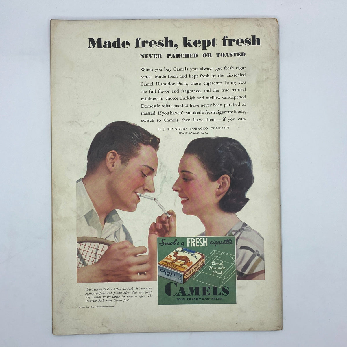 Vintage advertisement for Camel cigarettes in The New Yorker from October 1, 1932, depicting a couple sharing a moment, promoting the freshness and quality of Camel cigarettes.