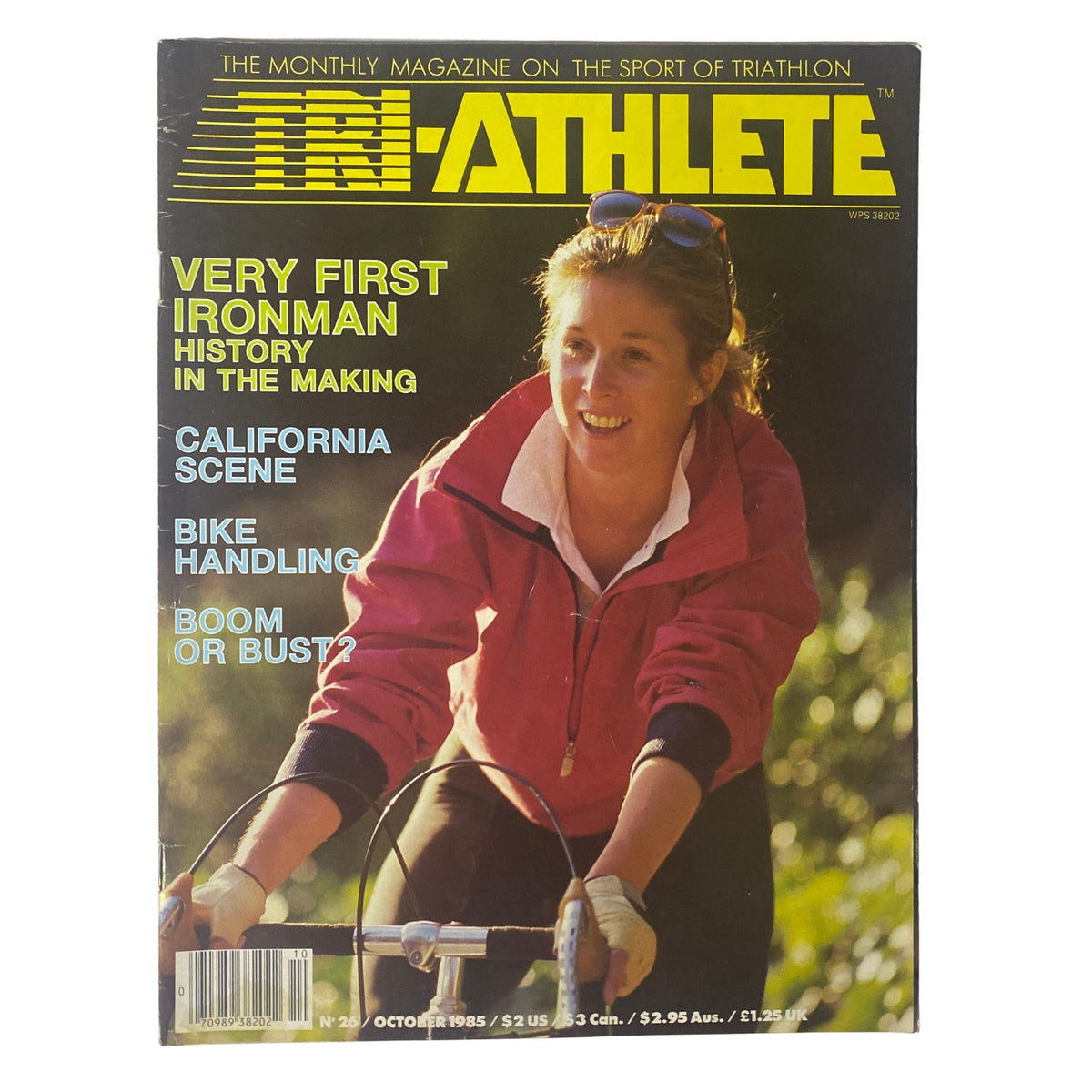 Cover of TriAthlete Magazine October 1985 No. 26 featuring the headline 'Very First Ironman History in the Making', showcasing a female athlete in a pink jacket, emphasizing bike handling and triathlon topics.