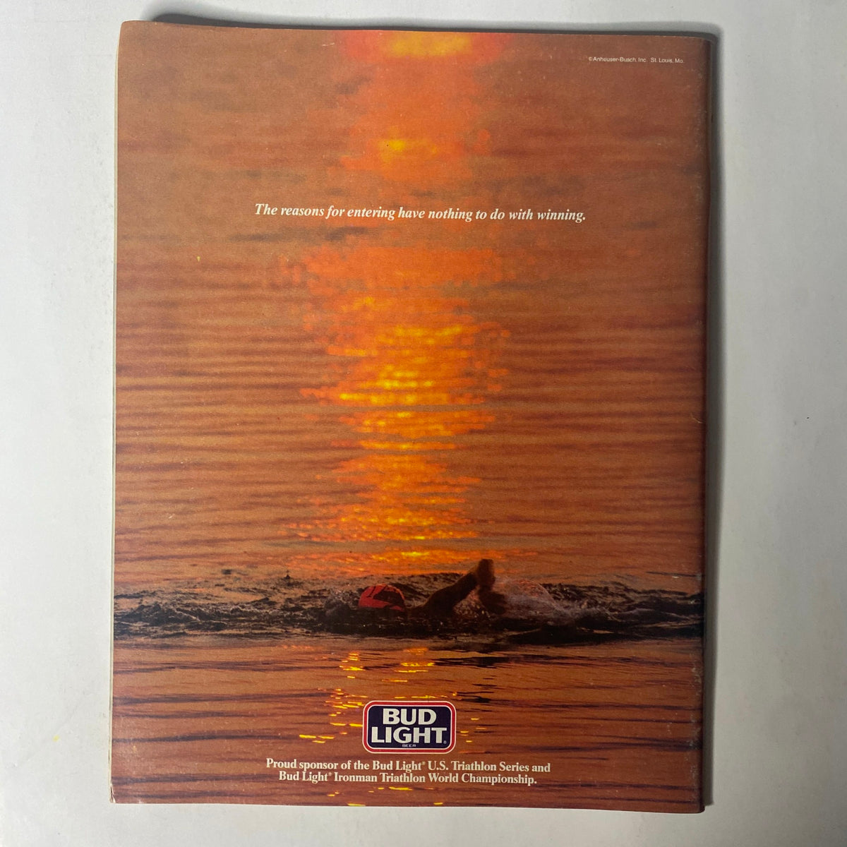 Back cover of Triathlete Magazine May 1987 No. 45 featuring a serene sunset reflection over water with a swimmer, highlighting Bud Light's sponsorship of triathlon events.