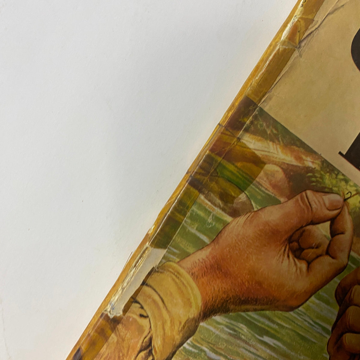Close-up view of the cover of Outdoor Life Magazine, July 1947 edition, highlighting detailed artwork of hands holding fishing hooks, emphasizing vintage outdoor activities.