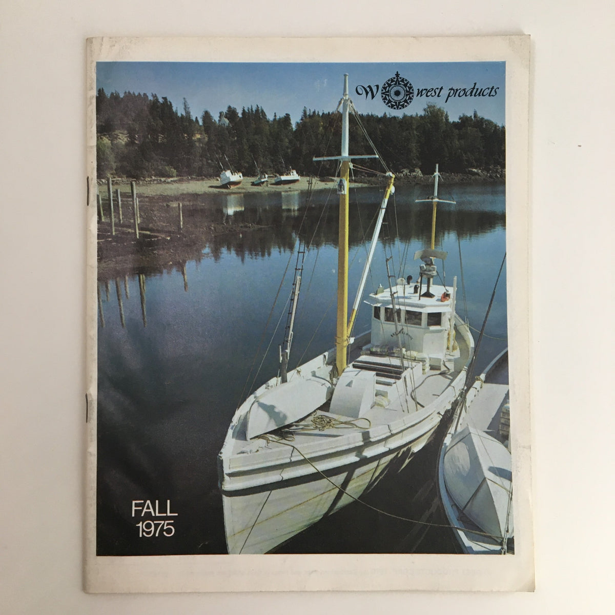 Cover of the 1975 Fall West Products Sailing Price Guide Catalog featuring a scenic marina with a fishing boat, showcasing vintage sailing products.
