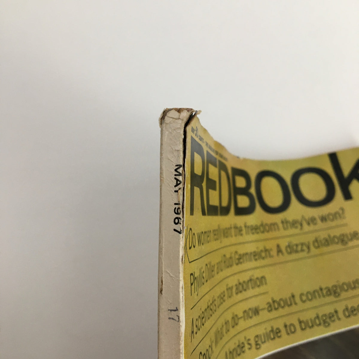 Close-up of the spine of Redbook Magazine May 1967 Vol. 129 #1 featuring minor wear and the publication date, highlighting its vintage condition.