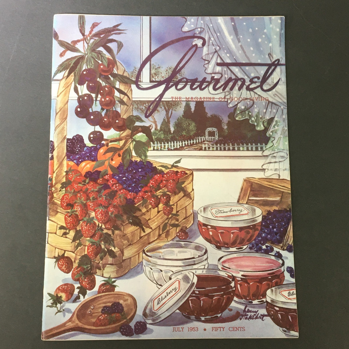 Vintage cover of VTG Gourmet The Magazine of Good Living July 1953 featuring a basket of fresh fruits and jellies, emphasizing the theme of a semi-rugged lifestyle.