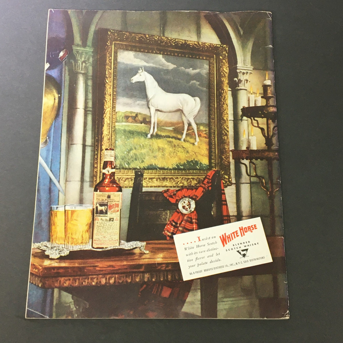 Back cover of VTG Gourmet The Magazine of Good Living May 1950 featuring an advertisement for White Horse Scotch, with an elegant setting including a bottle and a painting of a white horse.