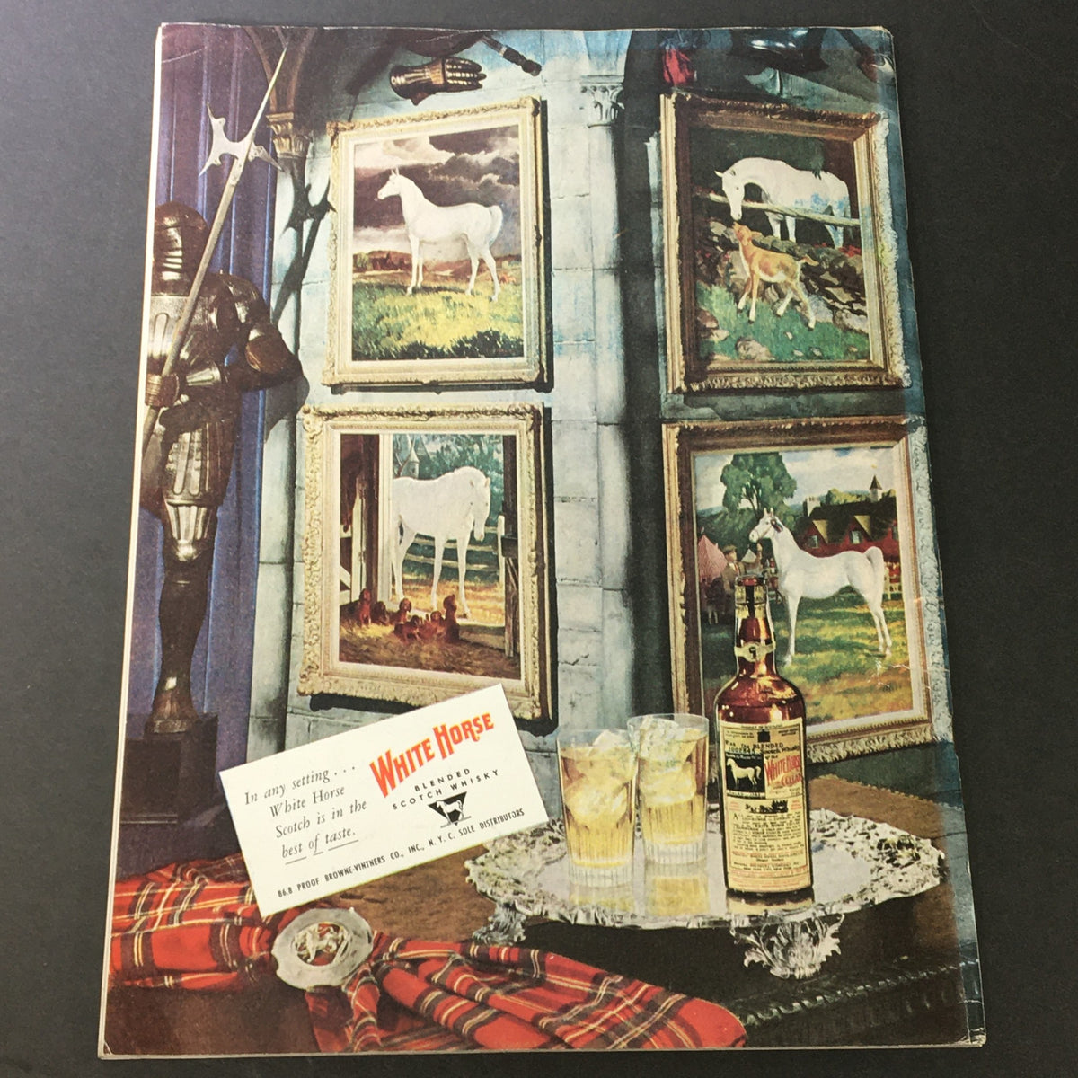 Back cover of VTG Gourmet Magazine, November 1950 - It's A Long Christmas, showcasing a nostalgic scene with paintings of horses and a bottle of White Horse Scotch, reflecting the magazine's classic charm.