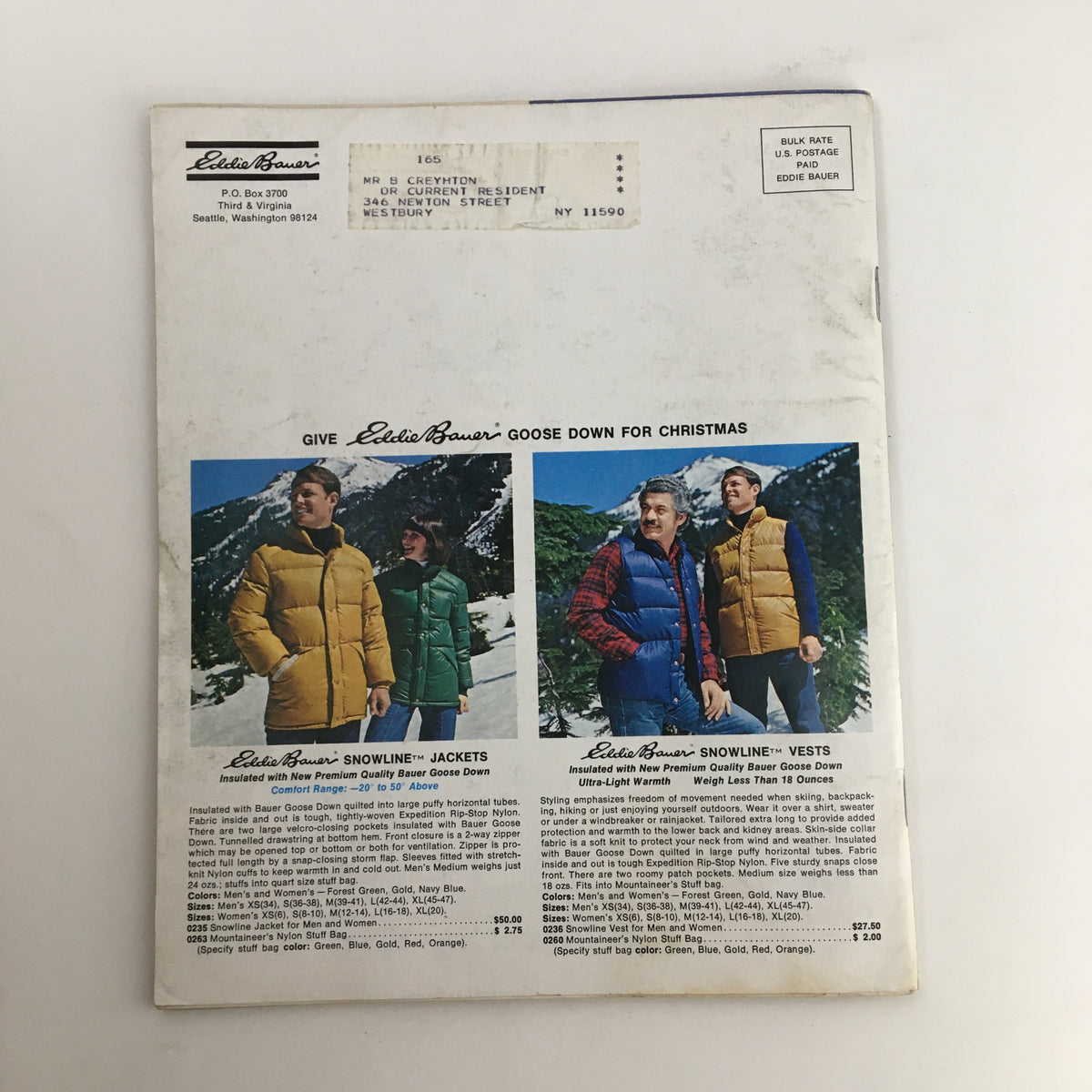 1976 Eddie Bauer Christmas Goose Down Garments Catalog cover featuring three models wearing colorful Goose Down jackets and vests in a snowy mountain landscape.