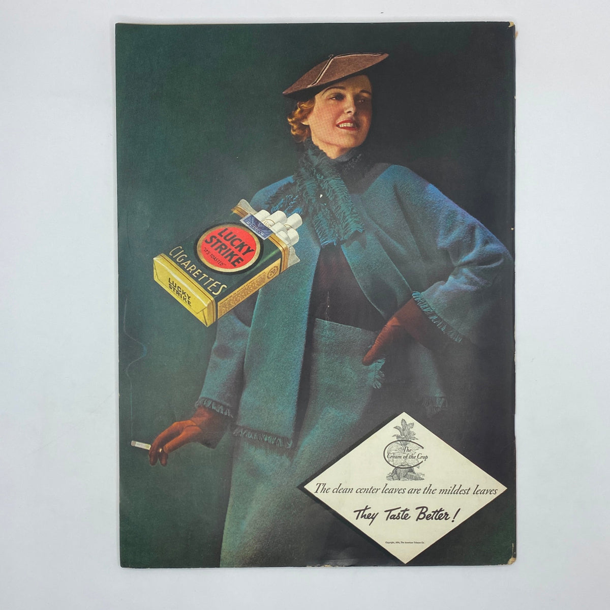 Colorful advertisement for Lucky Strike cigarettes showcasing a fashionable woman in a stylish blue coat and hat, featuring the product prominently. This is part of The New Yorker Complete Magazine November 24, 1934 William Cotton Cover.