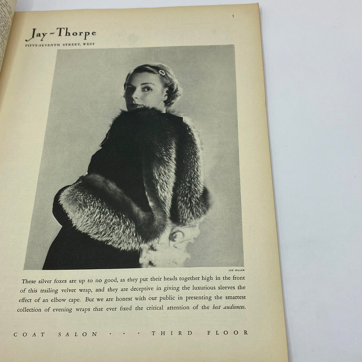 Vintage fashion advertisement from The New Yorker Complete Magazine October 14, 1933, featuring a model showcasing luxurious evening wraps.