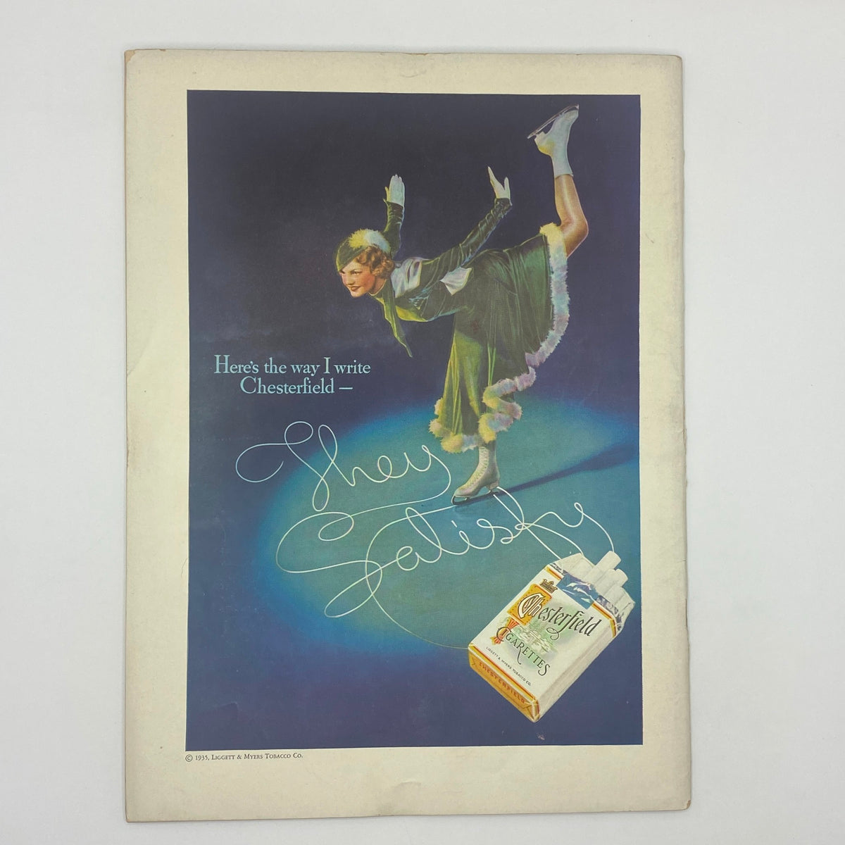 The New Yorker Complete Magazine January 12, 1935 Rea Irvin Cover, featuring an advertisement for Chesterfield cigarettes, with a stylish woman in a green dress performing on ice, reflecting 1930s fashion and advertising trends.