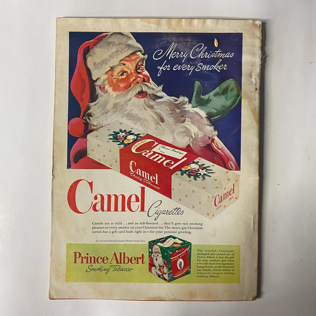 Christmas-themed advertisement in Outdoor Life Magazine December 1948 for Camel Cigarettes, featuring Santa Claus beside a gift box, promoting smoking tobacco with festive imagery.