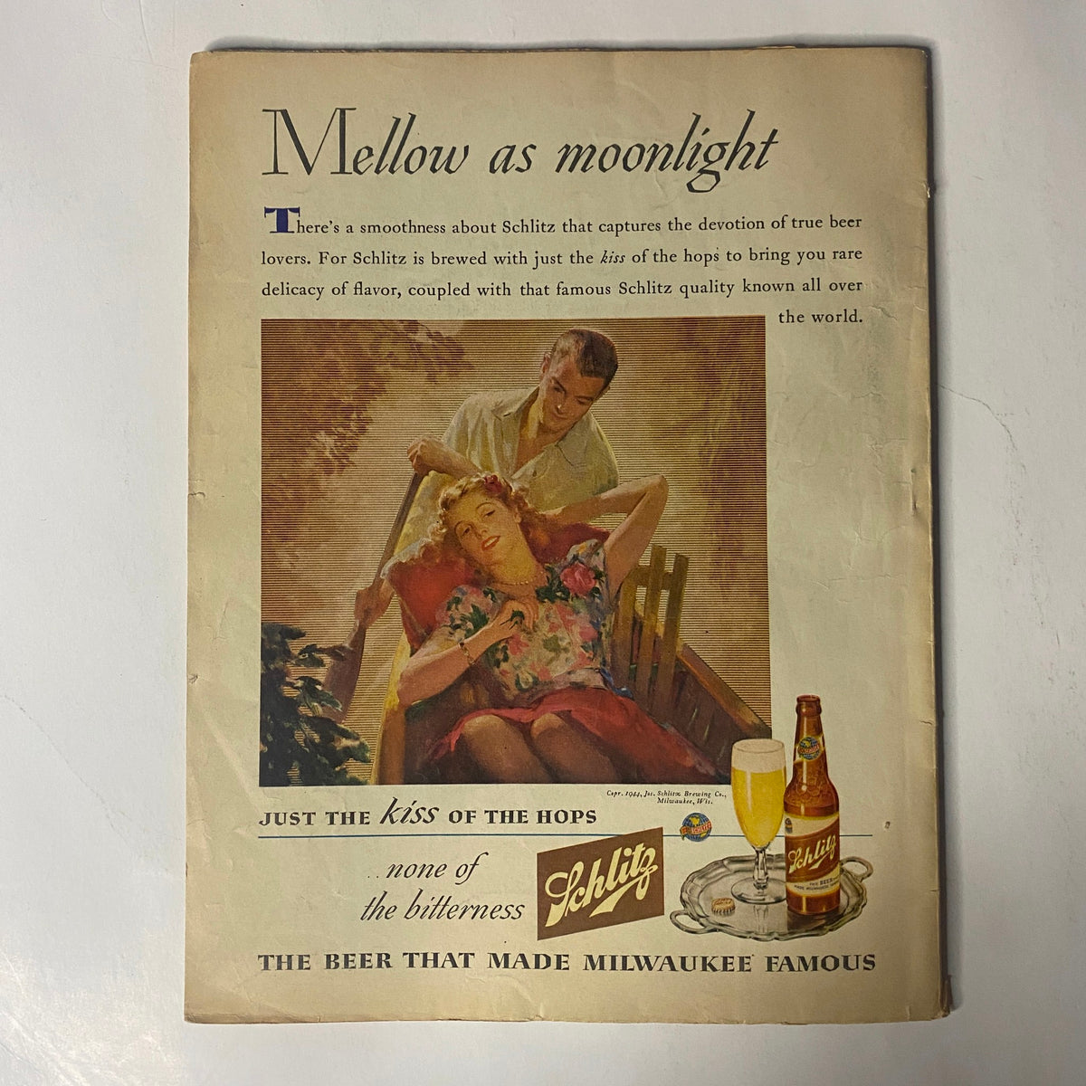 Back cover of Radio Mirror Magazine August 1944 showcasing an advertisement for Schlitz beer, featuring a romantic scene with a woman resting and a man pouring beer.
