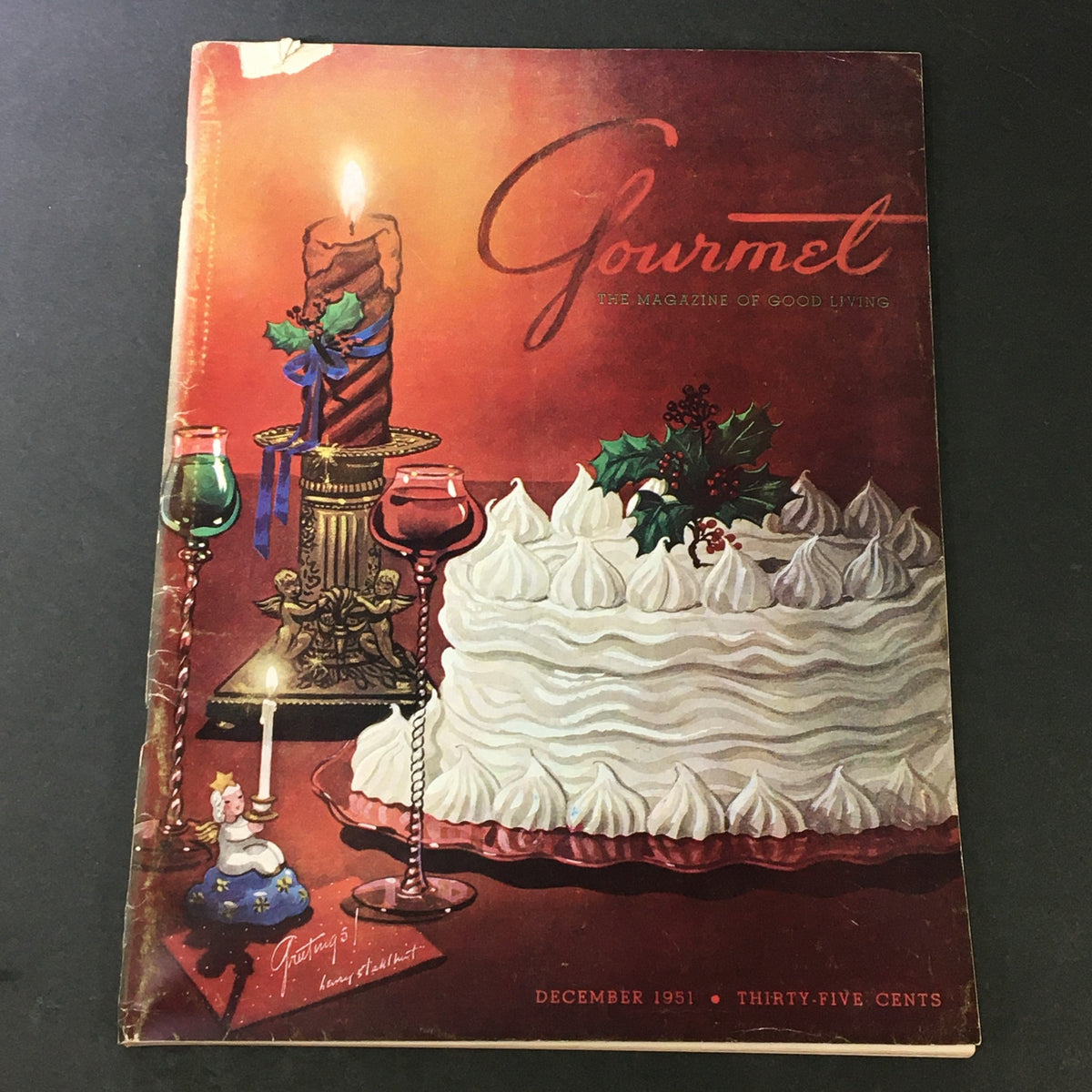 Cover of VTG Gourmet The Magazine of Good Living December 1951 showcasing a festive table setting with a beautifully decorated cake, a candle, and holiday decorations, highlighting the theme 'Extremities of Pig'.
