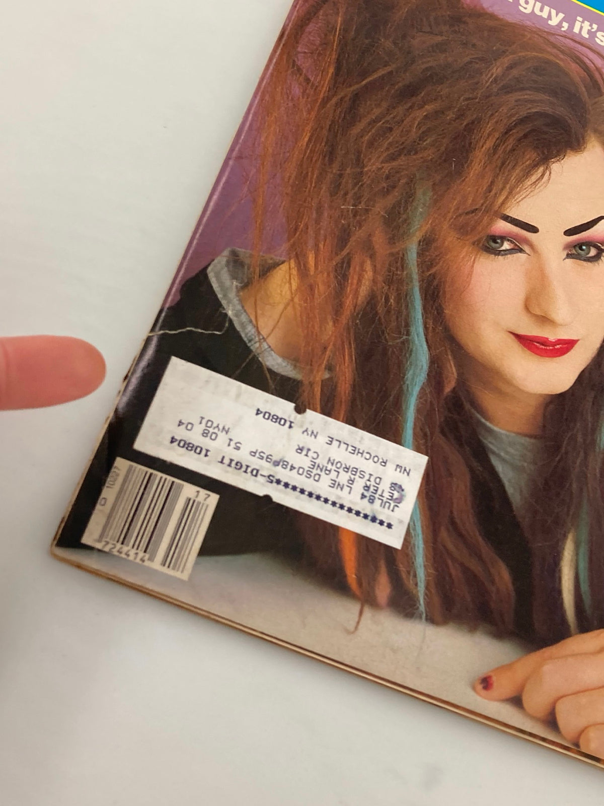 Close-up view of the cover of People Weekly Magazine from April 23, 1984, showcasing Boy George's expressive makeup and hairstyles, along with a visible label on the magazine.