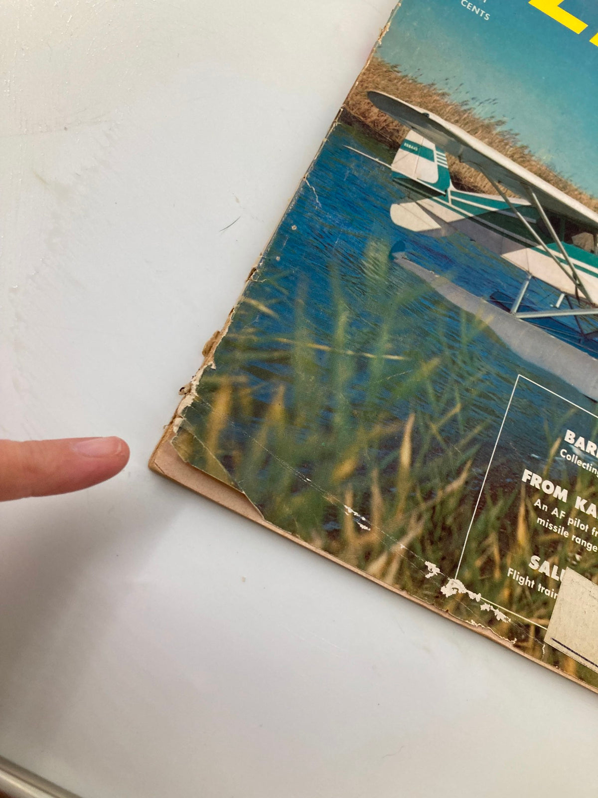 Close-up view of the corner of VTG Flying Magazine March 1958, showing details of the cover featuring the Tri-Pacer 160 on water, with slight wear indicating its vintage nature.