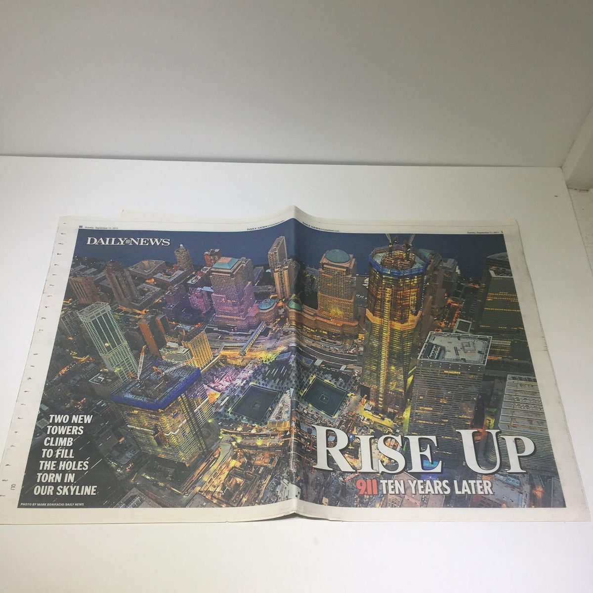 Cover image of the New York Daily News titled 'Rise Up 911 Ten Years Later', showcasing a stunning aerial view of a city skyline illuminated at night.
