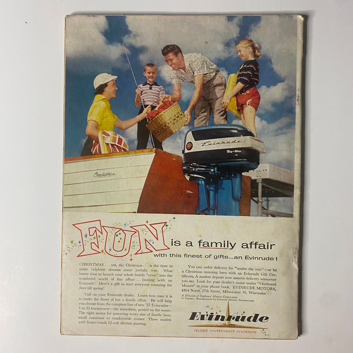 Back cover of Outdoor Life Magazine December 1956 showcasing a family enjoying time together, promoting the Evinrude outboard motor.