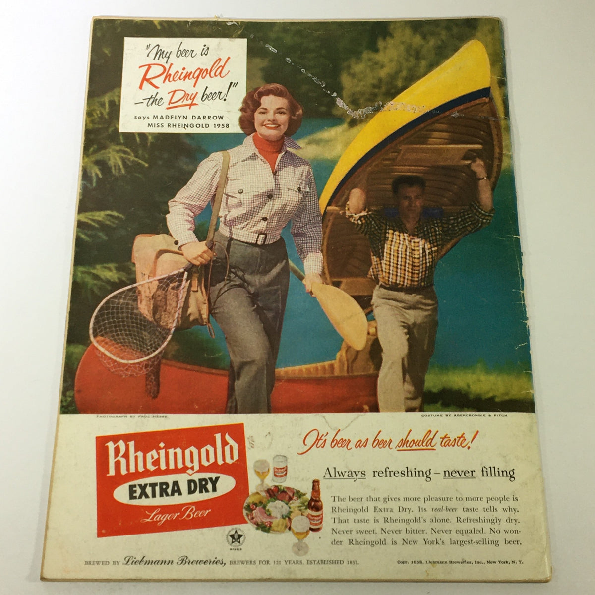 Back cover of VTG Gourmet The Magazine of Good Living July 1958 - High-Style Barbecue showing a vintage advertisement for Rheingold Extra Dry Lager Beer featuring a woman model and a man in a canoe.