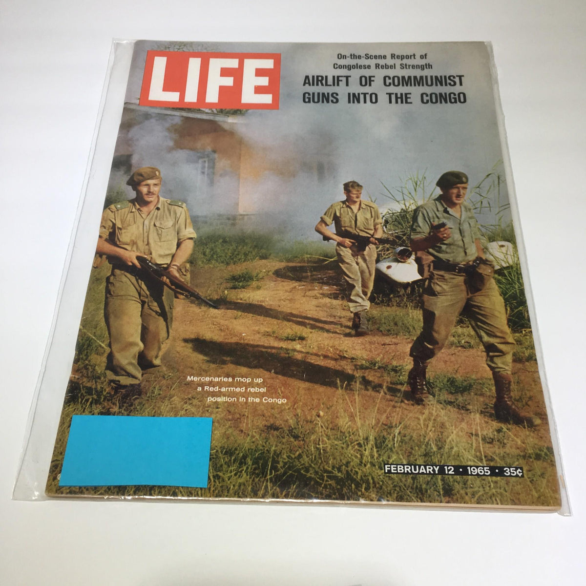 Life Magazine cover from February 12, 1965, featuring a story on the airlift of communist guns into the Congo, depicting mercenaries in military uniforms carrying firearms amidst a lush green landscape.