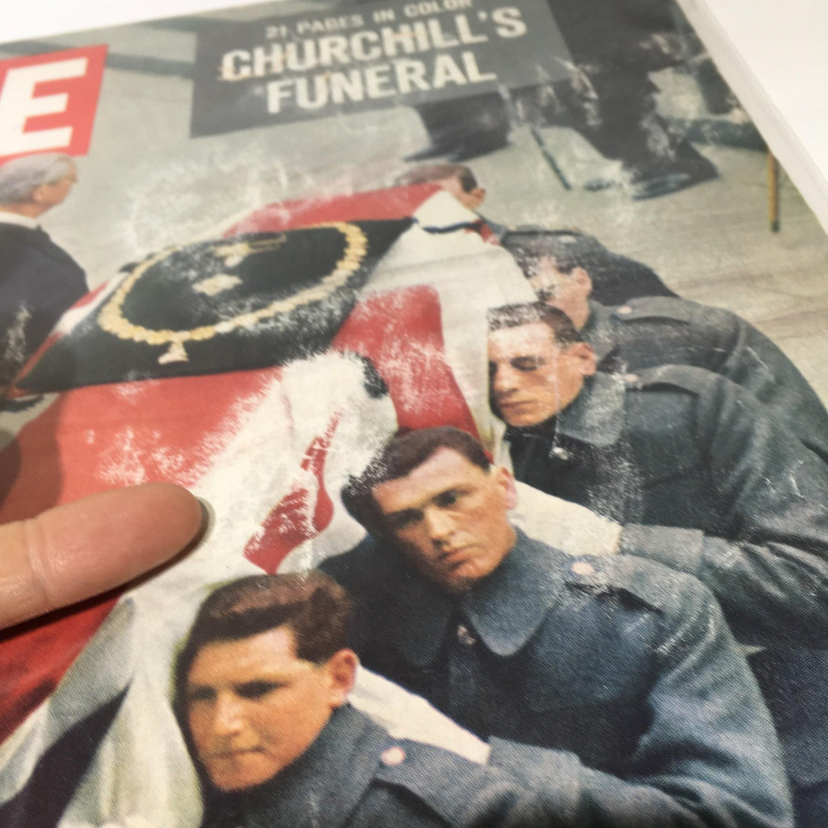 Close-up view of the Life Magazine cover from February 5, 1965, showcasing Winston Churchill's Funeral, focusing on the soldiers in uniform and the casket adorned with insignia.
