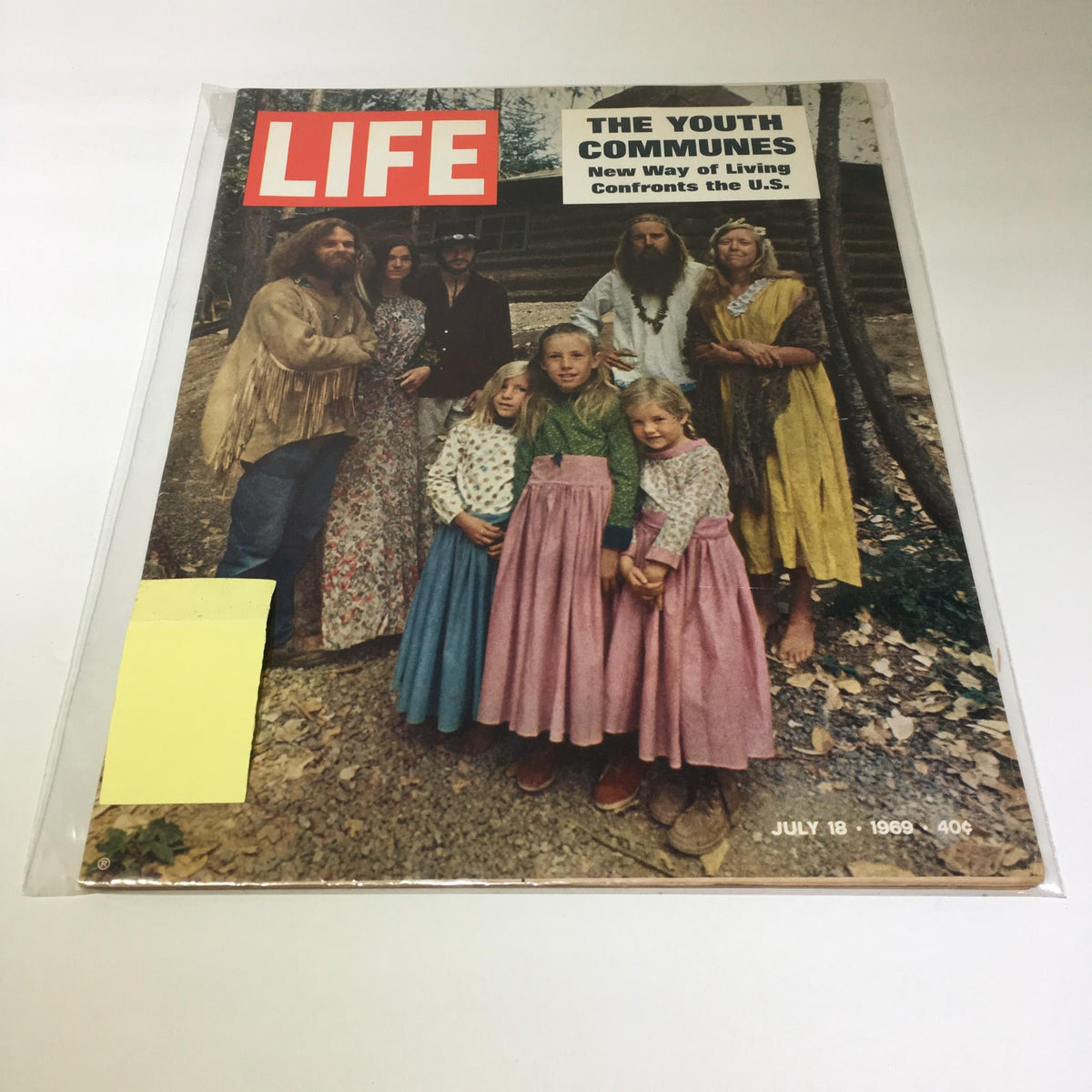 Vintage Life Magazine cover from July 18, 1969 featuring the title 'VTG Life Magazine July 18 1969 - Communes New Way of Living Confronts The US'. Image shows a group of individuals representing the 1960s counterculture, adorned in period-specific clothing, set against a natural backdrop. Ideal for collectors and those interested in historical publications.