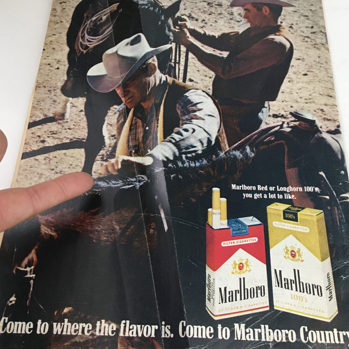 Vintage Marlboro advertisement featuring cowboys and cigarette packs, illustrating the slogan 'Come to where the flavor is. Come to Marlboro Country.' from the July 25, 1969 issue of Time Magazine, Volume 94, Number 4.
