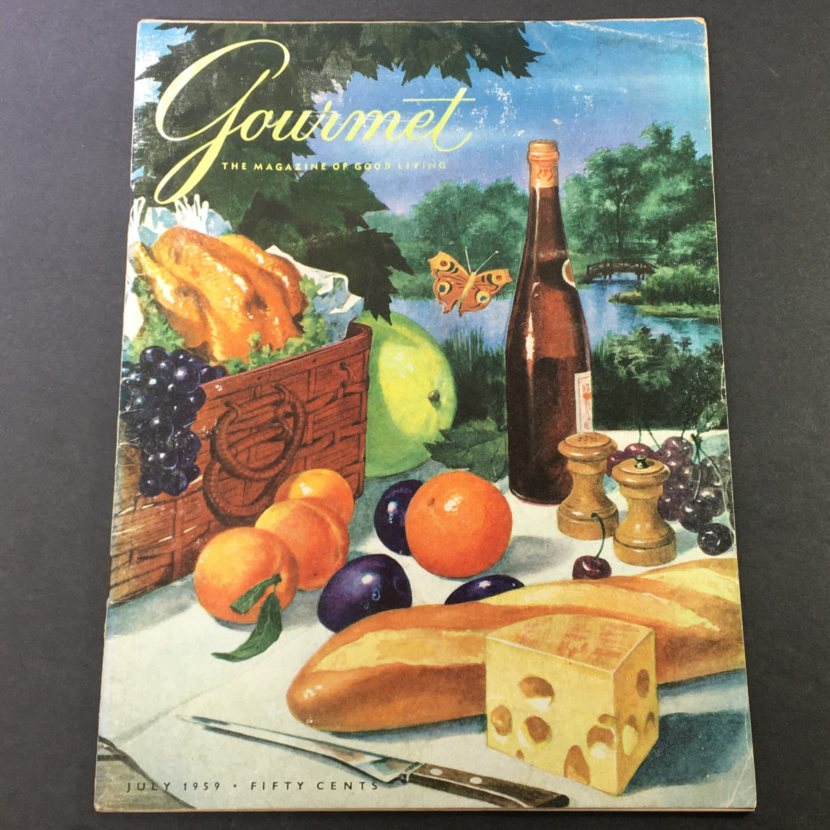 Cover of VTG Gourmet: The Magazine of Good Living, July 1959 edition, featuring a colorful food arrangement with grilled chicken, fruits, and a scenic backdrop.