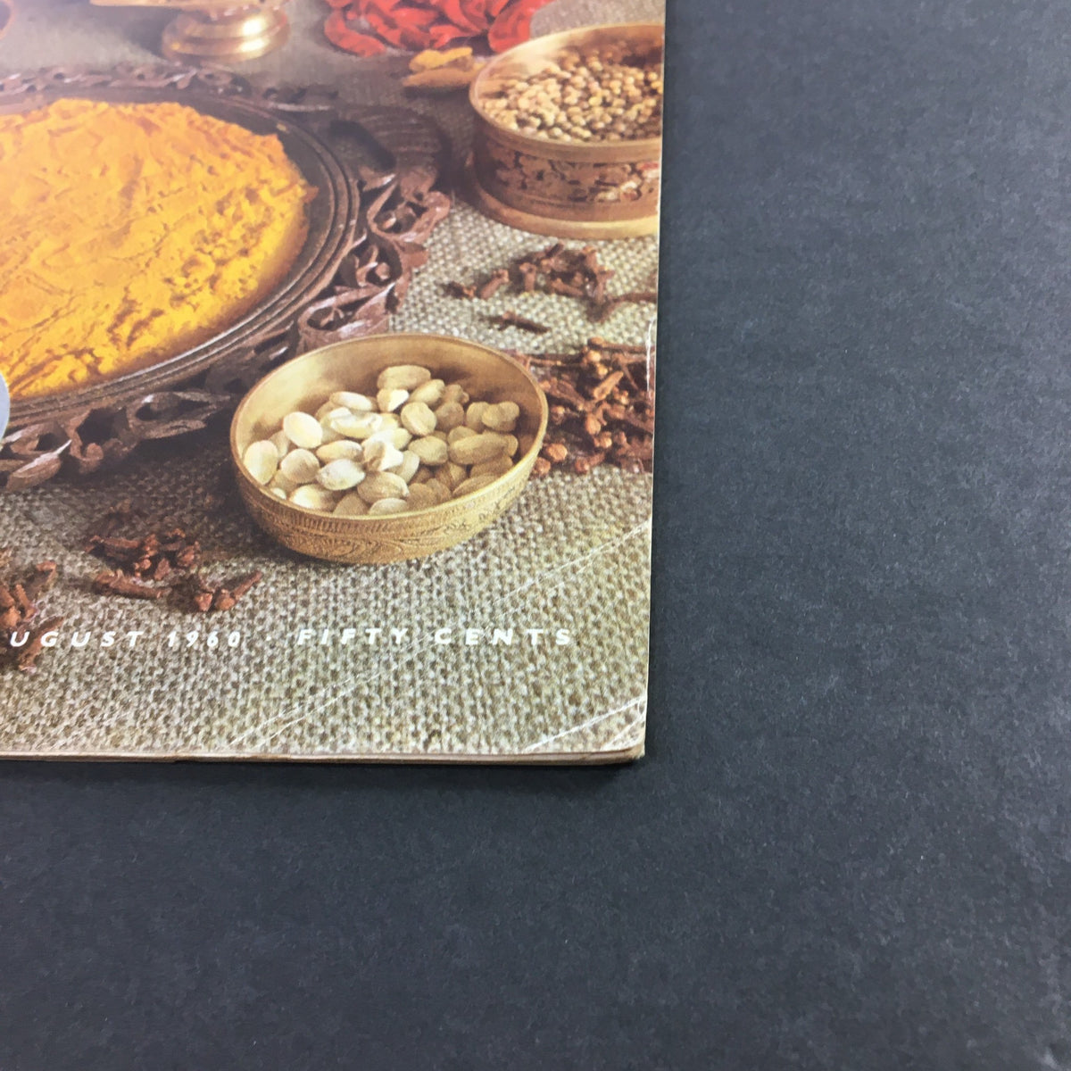 Close-up of the cover of VTG Gourmet: The Magazine of Good Living, August 1960, highlighting spices and gourmet cooking elements, reflecting the magazine's culinary aesthetic.