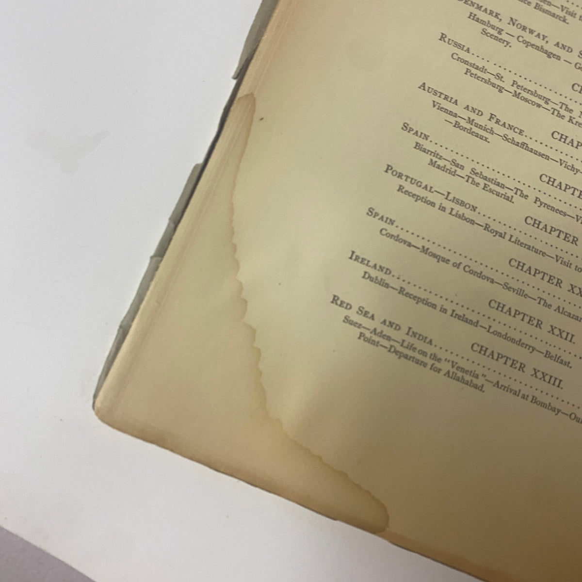 Image showcasing the damaged edge of a page from 'Around the World with General Grant' by John Russell Young, indicating the book's vintage condition.