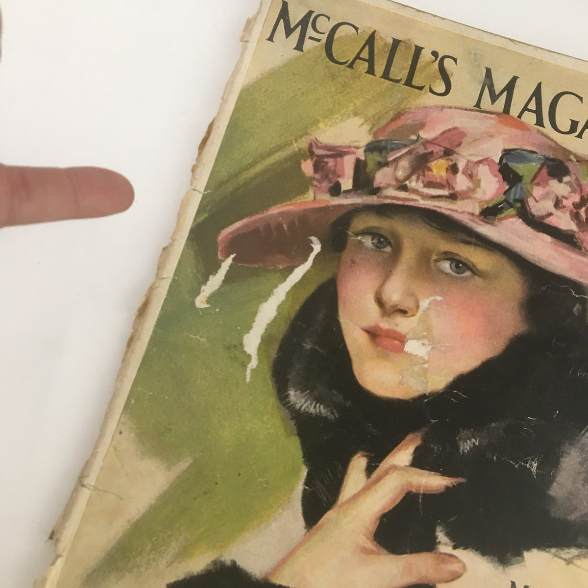 Close-up view of the cover of VTG McCall's Magazine March 1916 with the woman's portrait, showcasing wear and vintage charm.
