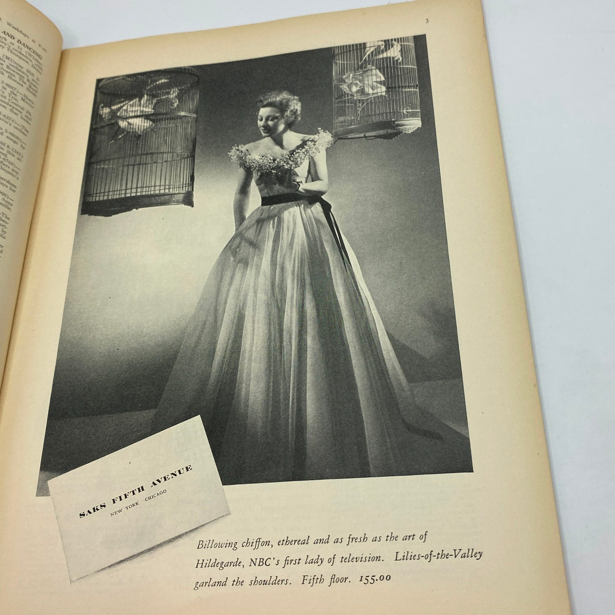 Fashion advertisement in The New Yorker magazine dated May 29, 1937, showcasing a model in an elegant dress surrounded by birdcages, highlighting 1930s fashion.
