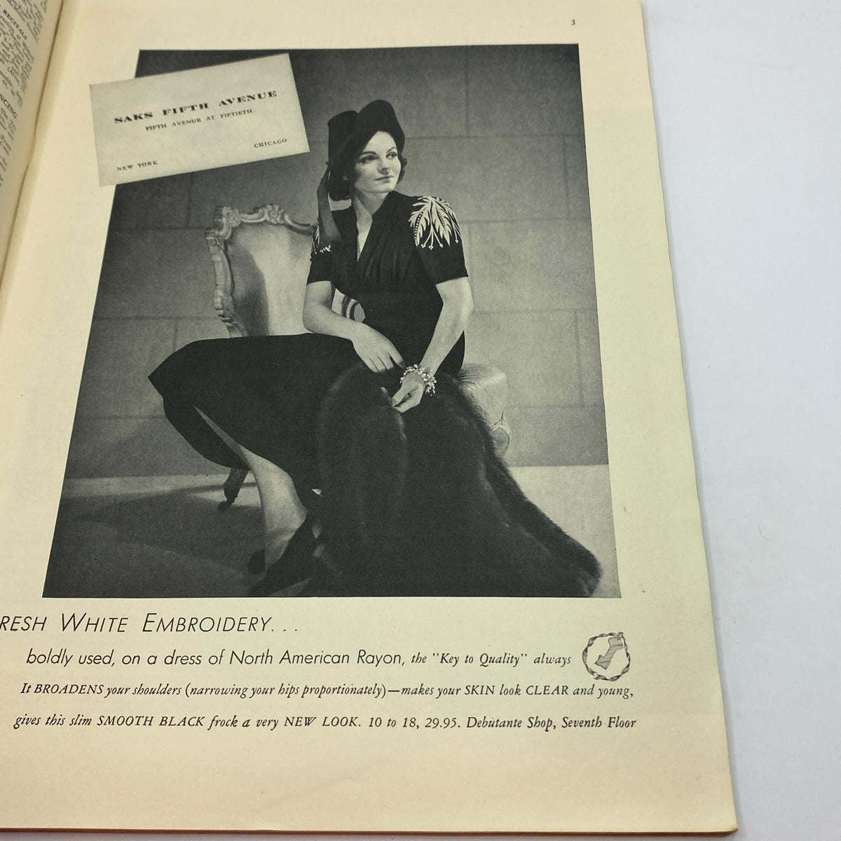 Advertisement from The New Yorker magazine dated November 12, 1938 depicting a stylish model seated in a black dress, promoting fresh white embroidery from Saks Fifth Avenue.