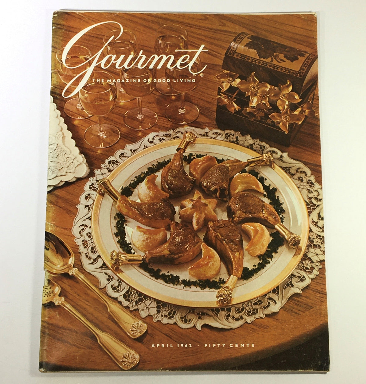 Cover of VTG Gourmet The Magazine of Good Living, April 1962 issue titled 'The Leaves of Spring', featuring an elegant dinner setting with a beautifully plated dish.