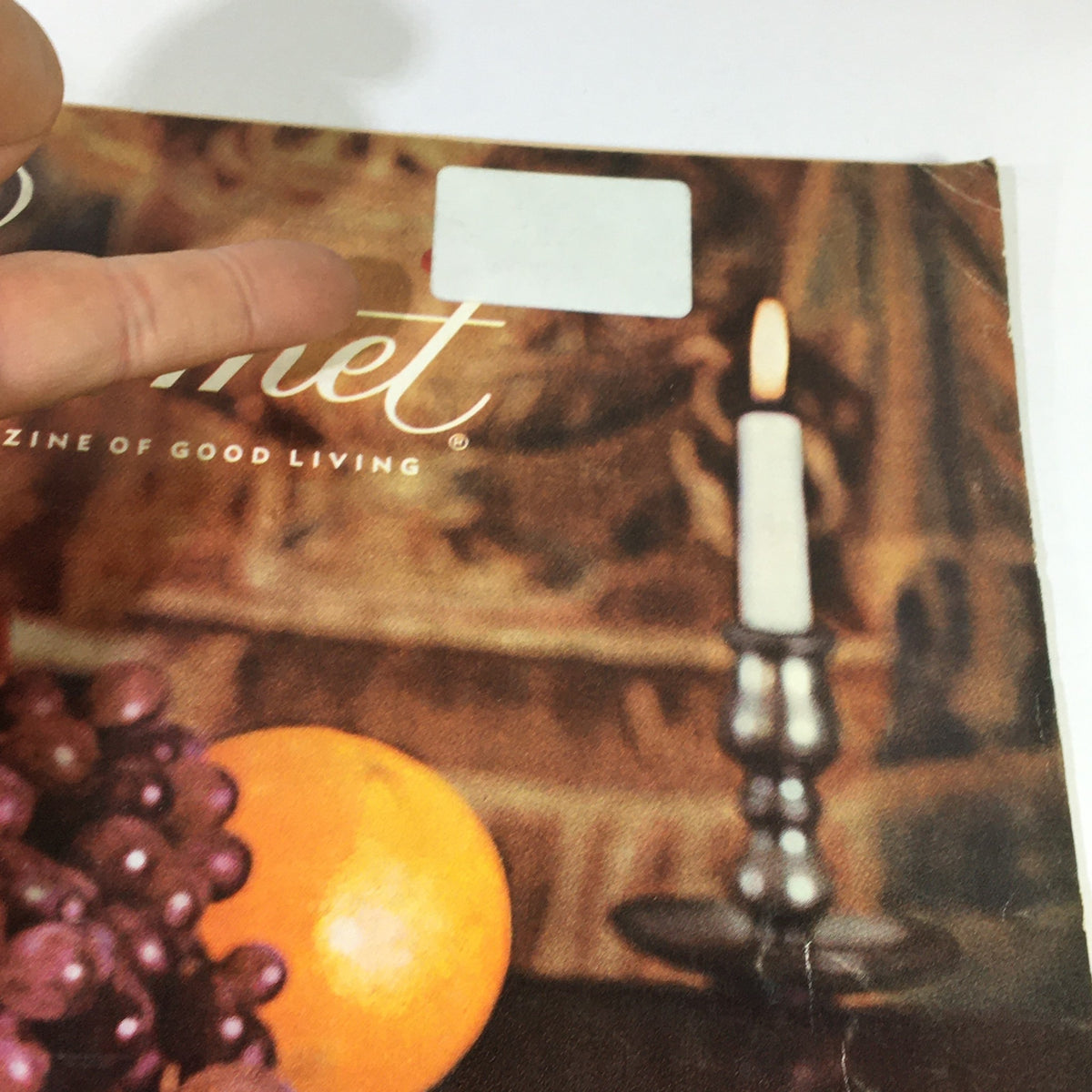 Close-up detail of the cover of VTG Gourmet: The Magazine of Good Living April 1964 showcasing a label and candle beside fruits.