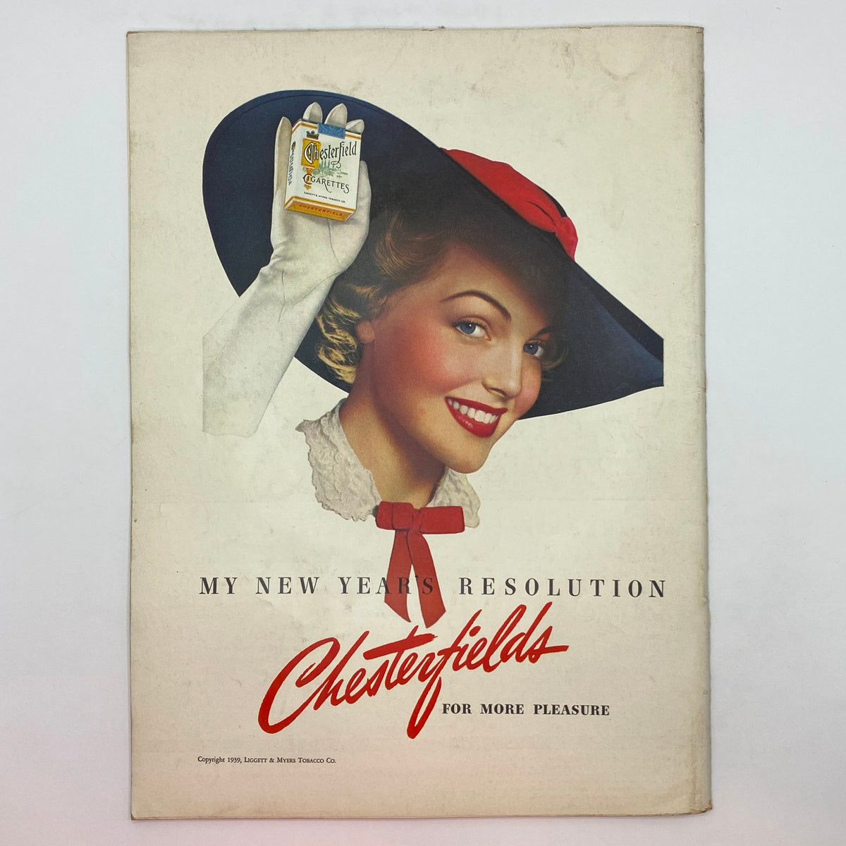 Vintage advertisement from The New Yorker January 14, 1939 featuring a smiling woman with a large hat holding a Chesterfield cigarette pack, promoting the brand with the slogan 'My New Year's Resolution Chesterfields for More Pleasure.'