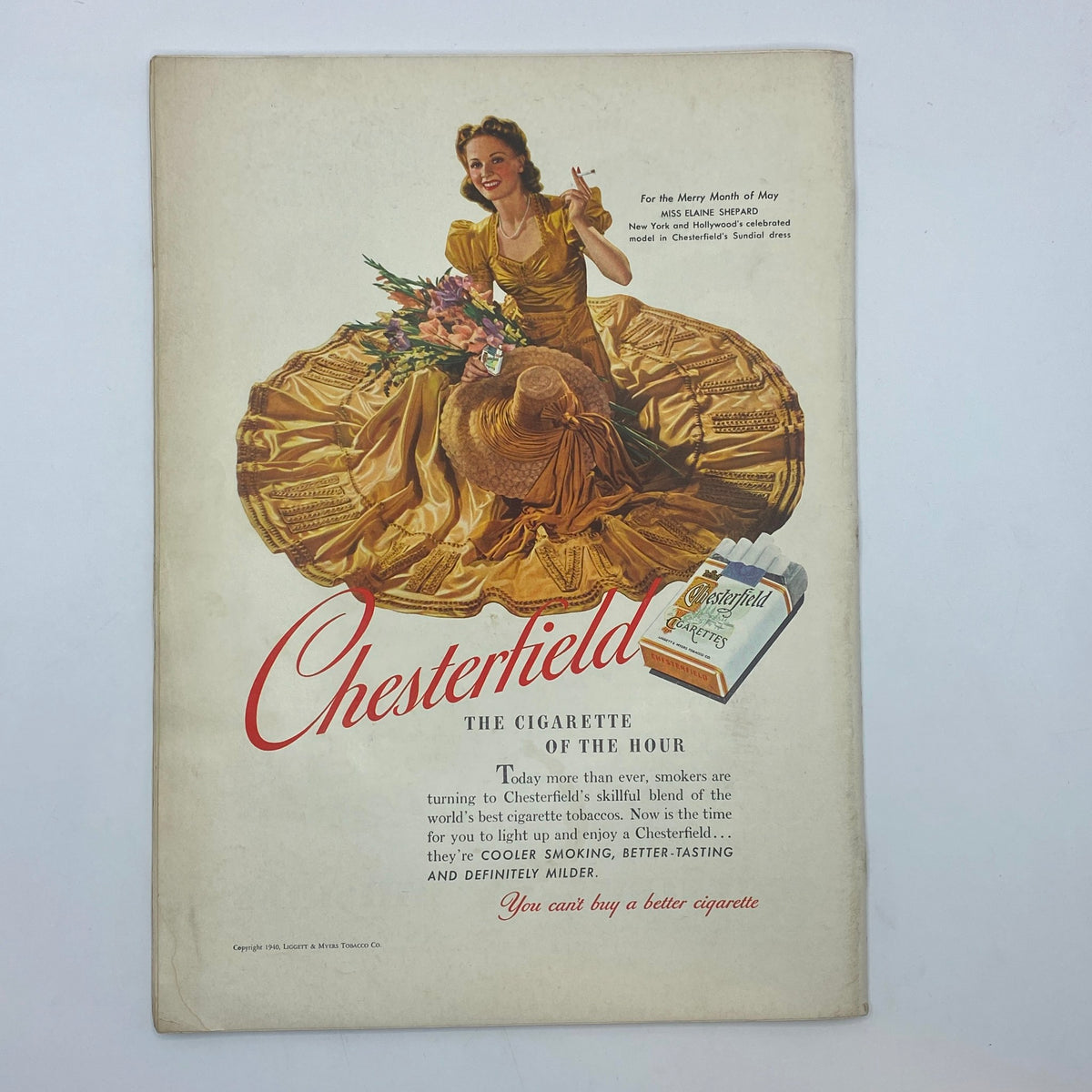 Vintage Chesterfield Tobacco advertisement featuring a woman in a golden dress surrounded by flowers. This ad highlights Chesterfield as the 'Cigarette of the Hour,' promoting its cool, smooth smoking experience. The image is part of The New Yorker Complete Magazine April 27, 1940, James Thurber Cover.