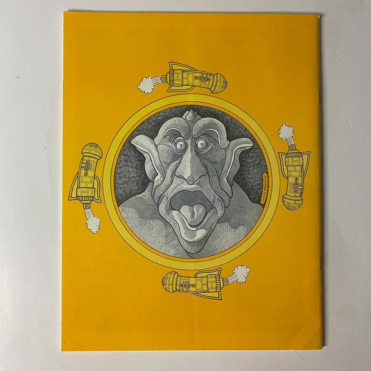 Back cover of Closeup Magazine 1975 No. 1 featuring a detailed illustration of a fantastical creature surrounded by rocket ships, maintaining a vibrant yellow theme.